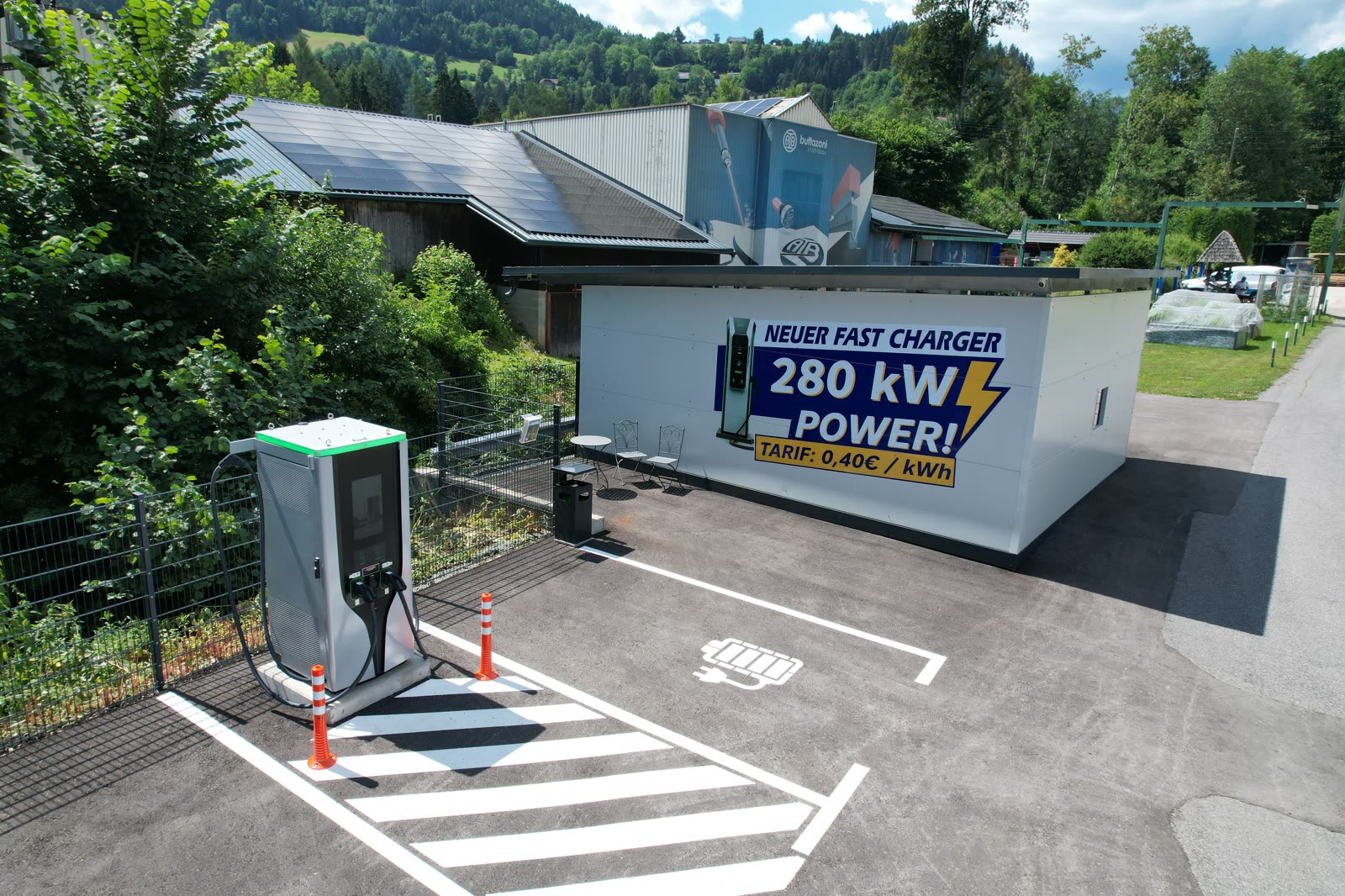 Drohnenaufnahme der E-Ladestation mit dem 280-kW-Banner am Gebäude der Buttazoni GmbH